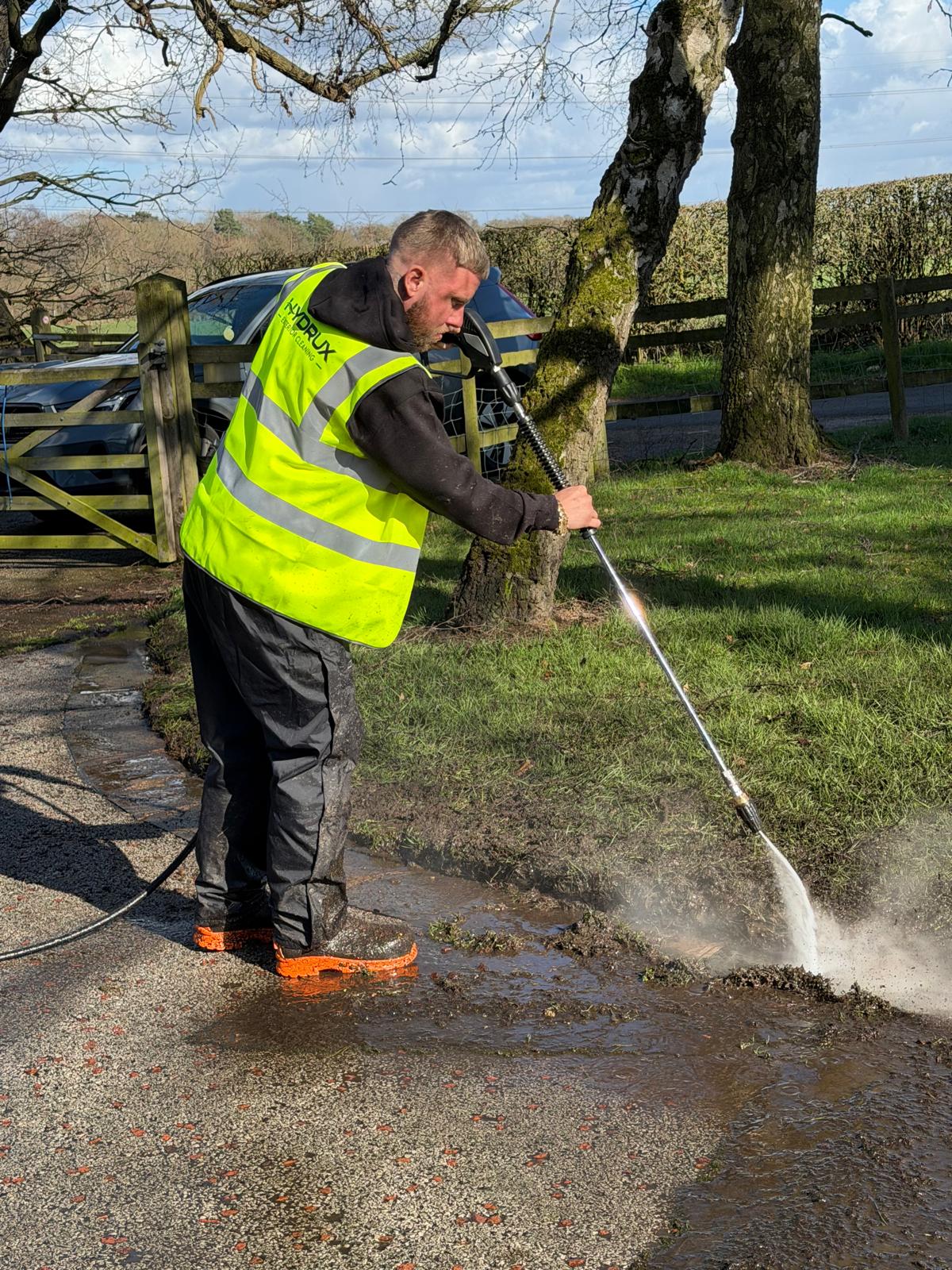 HYDRUX operator pressure washing a country driveway